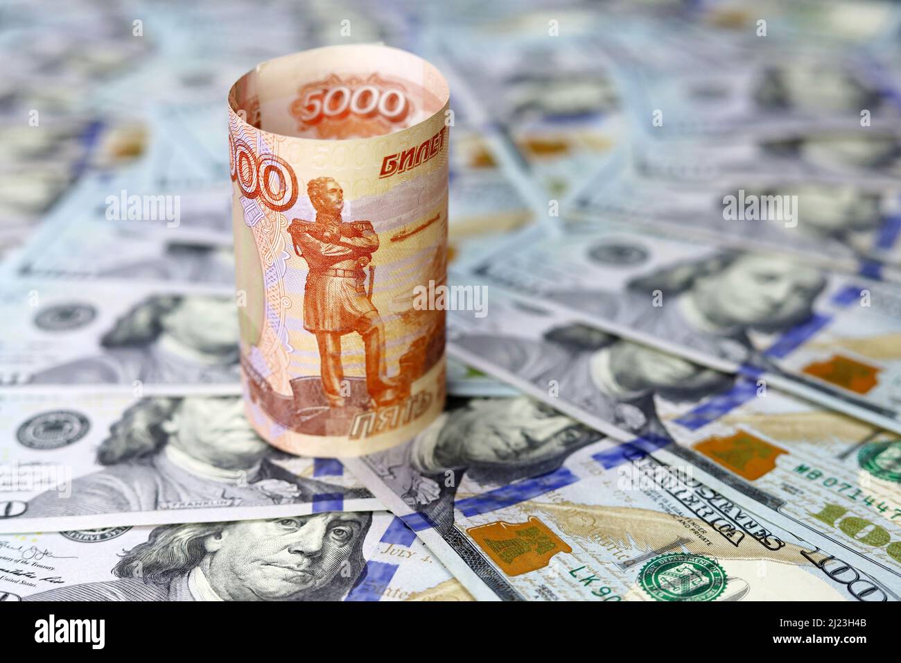 Banconota da rubli russa su sfondo di dollari americani. Concetto di tasso di cambio, sanzioni americane contro la Russia Foto Stock