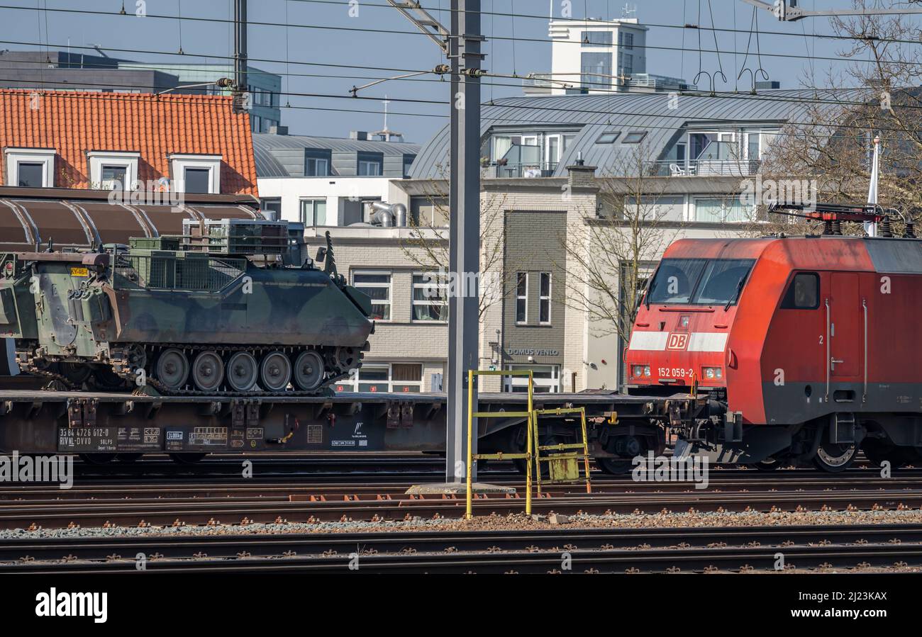 Venlo, provincia Limburgo, Paesi Bassi, 26.03.2022, treno Cargo di proprietà della compagnia ferroviaria nazionale tedesca Deutsche Bahn (DB) che trasporta la ve militare Foto Stock