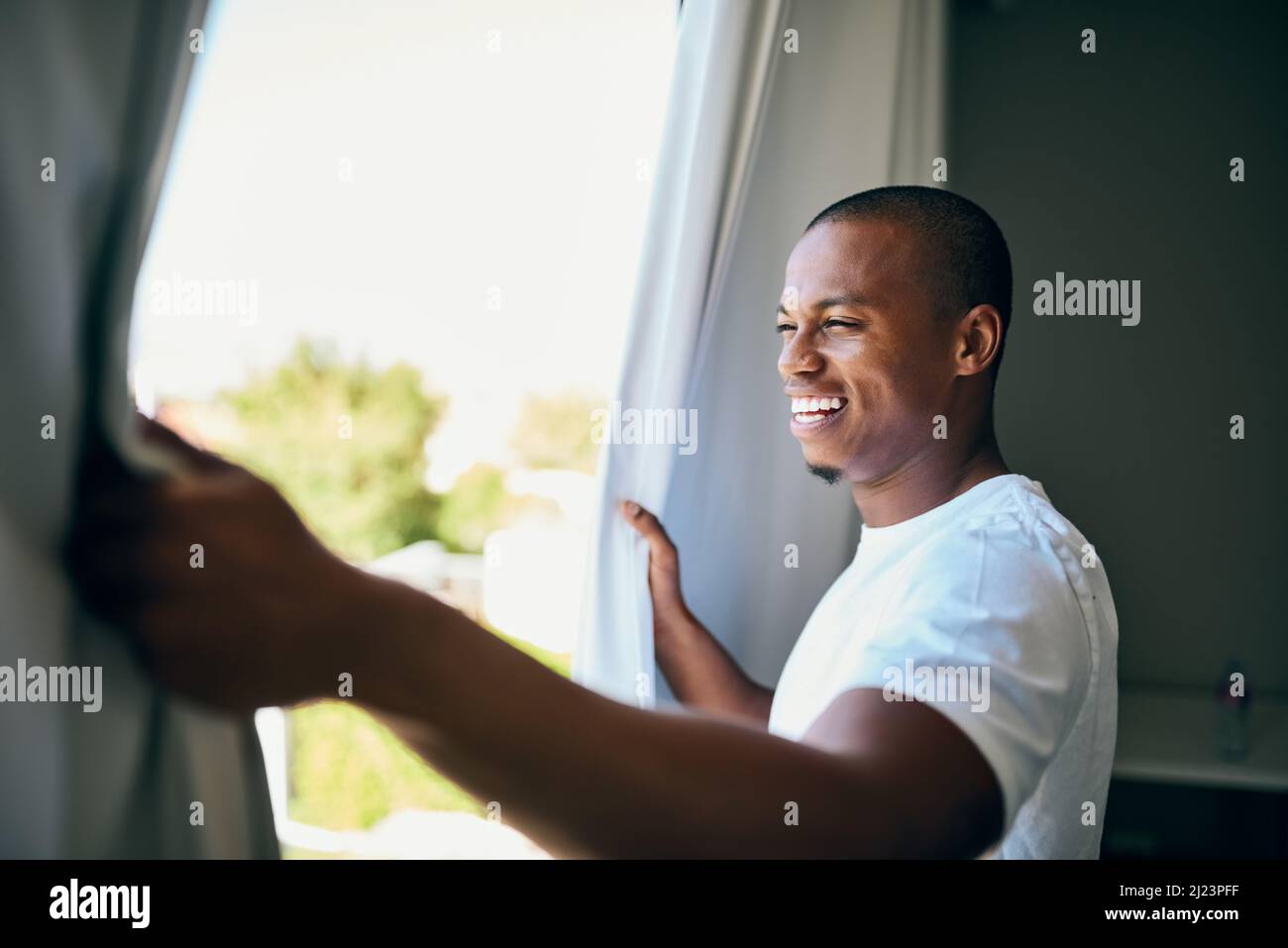 Possibilità è fuori là. Sparò un bel giovane uomo che aprì le tende della sua camera al mattino. Foto Stock