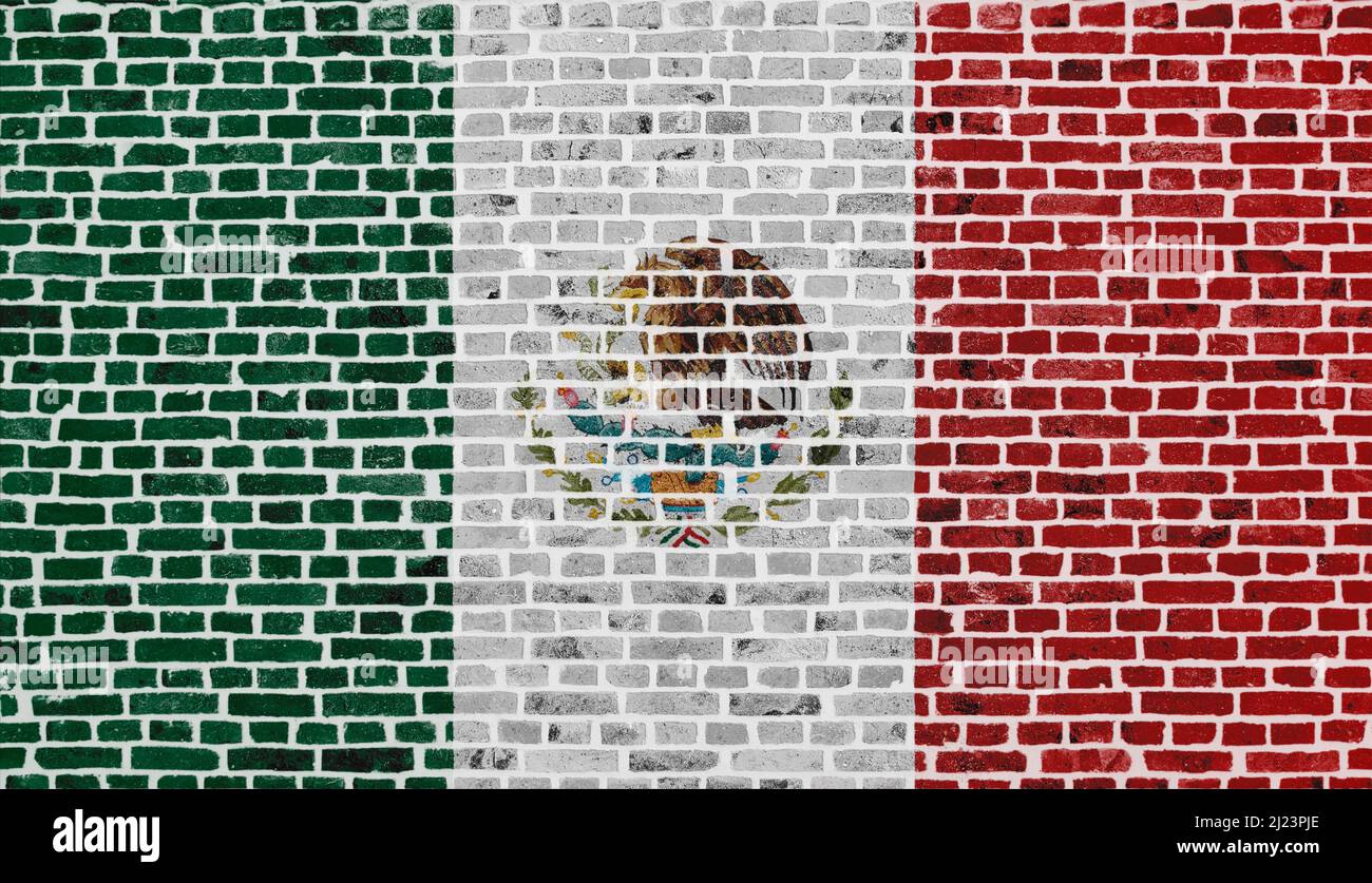 Primo piano su un muro di mattoni con la bandiera del Messico dipinta su di esso. Foto Stock