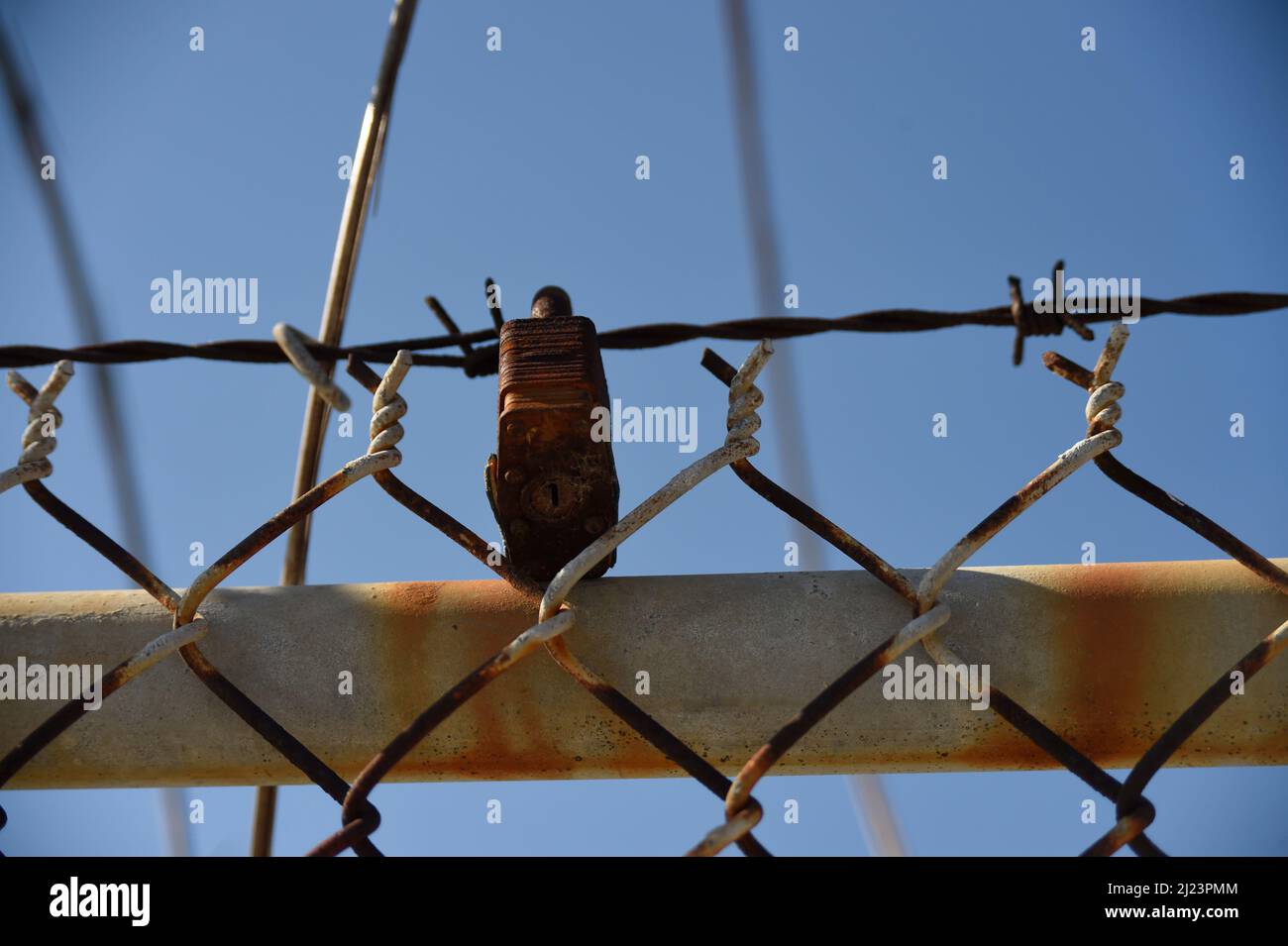 Blocco arrugginito su una vecchia recinzione della maglia della catena Foto Stock