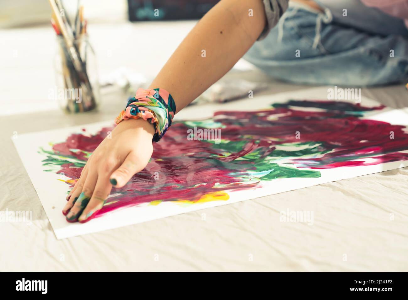 Arte astratta l'artista moderno dipinge sulla tela con le mani. Primo piano. Foto di alta qualità Foto Stock