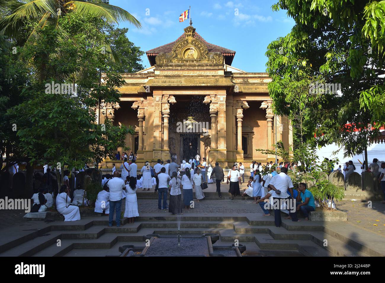 Adoratori all'ingresso di Kelaniya Raja Maha Vihara, un tempio buddista situato in un sobborgo di Colombo Foto Stock