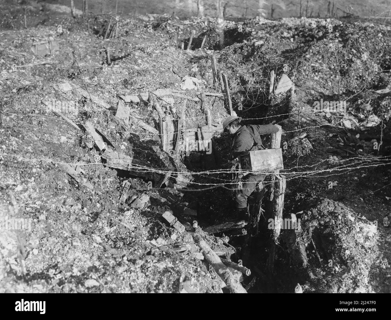 Un soldato, forse britannico, si arrampica attraverso una trincea catturata in prima linea tedesca vicino a Beaumont Hamel, 26th novembre 1916. Oltre al tradizionale filo spinato, il filo della concertina non spinato è chiaramente visibile sopra di lui. Foto Stock