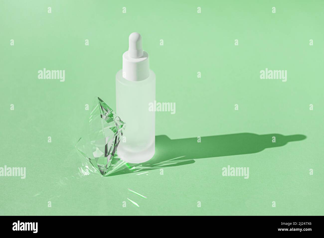 Prodotto per la cura della pelle del siero con collagene e peptide in bottiglia bianca con contagocce su sfondo verde con effetti luminosi rifrangenti a prisma di cristallo e. Foto Stock