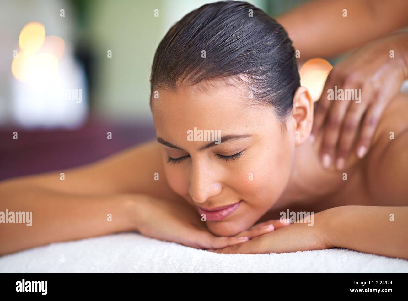 Solo Rallenta. Scatto di una giovane donna che si gode un massaggio alla schiena in una spa. Foto Stock