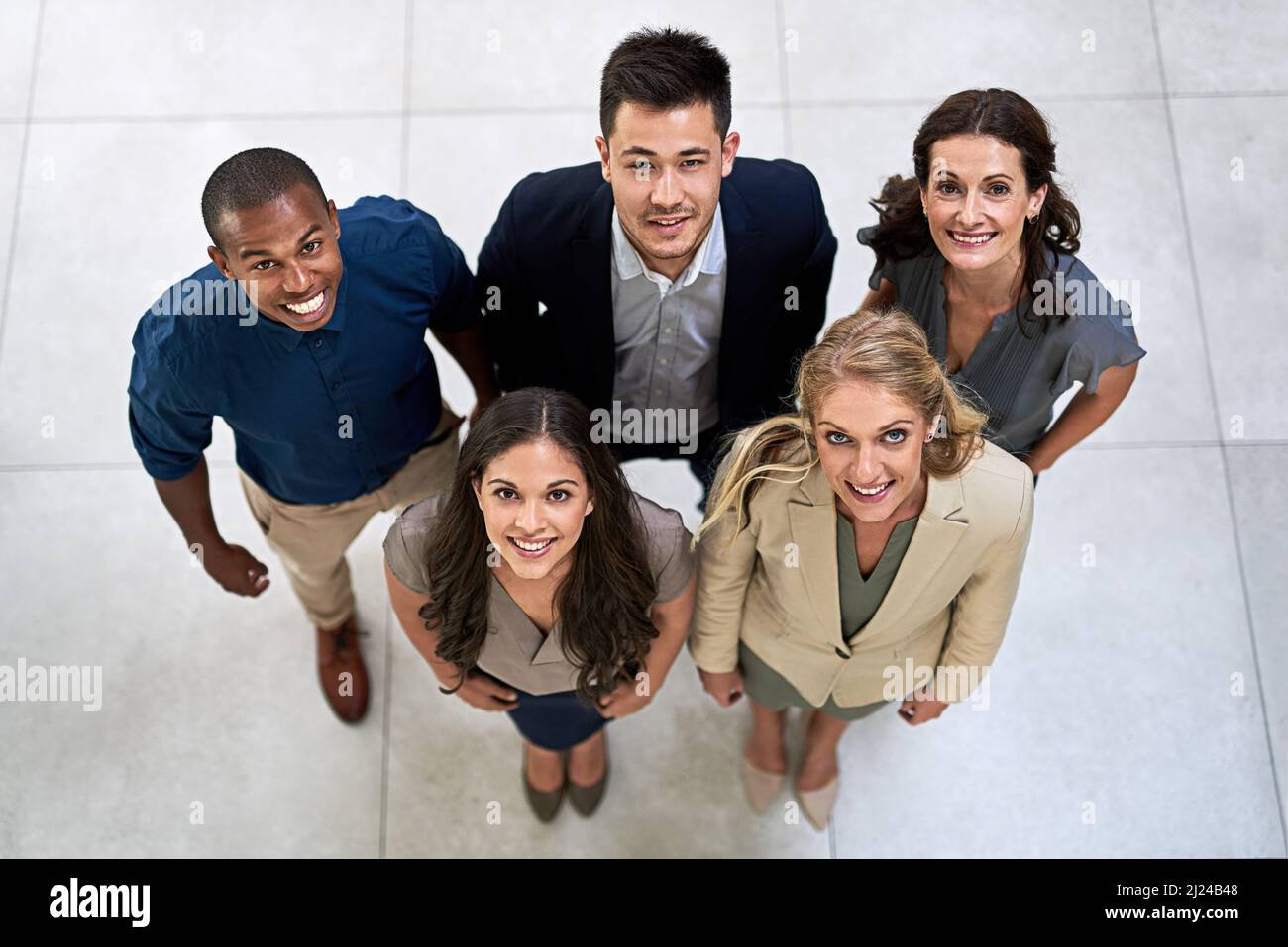 I nostri sorrisi sono stati vinti con successo. Ritratto ad alto angolo di un team di uomini d'affari che si posano insieme nel loro ufficio. Foto Stock