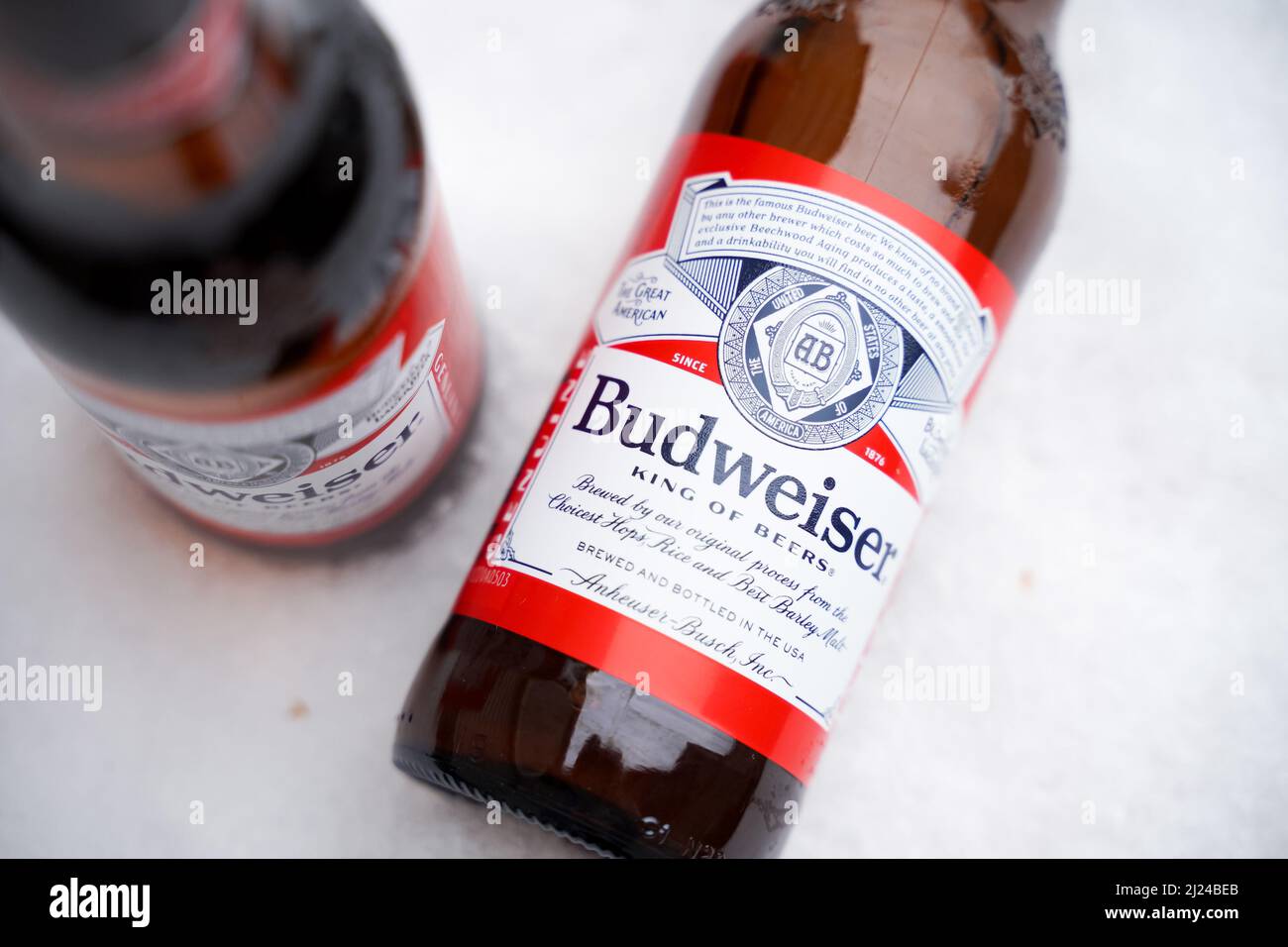 Marinette,WI,USA -DEC1-2021: Un venditore all'aperto vende birra Budweiser refrigerata su un tavolo con molta neve. Bottiglie di birra Bud, un pallido all'americana Foto Stock