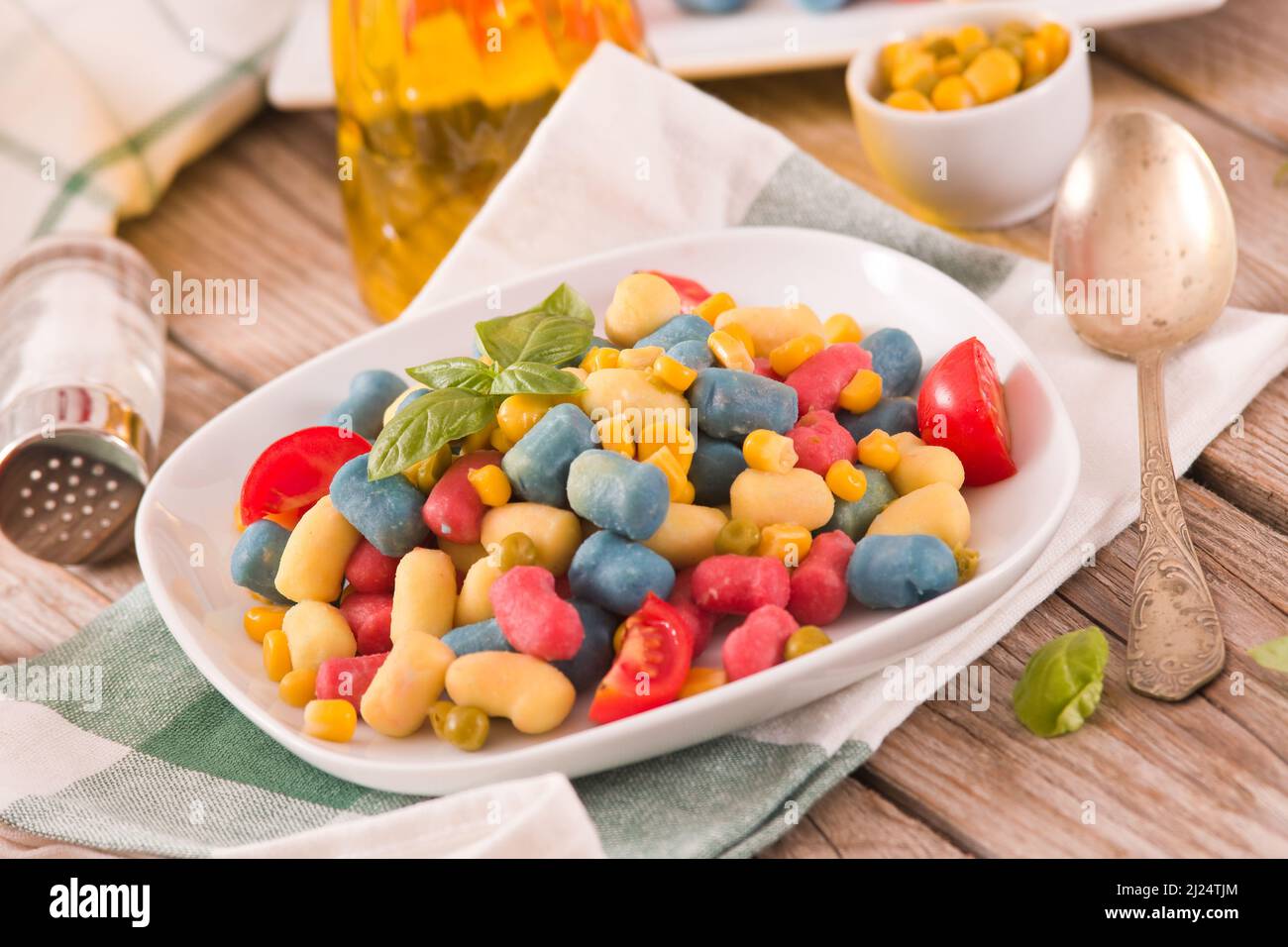 Gnocchi colorati con verdure e mais dolce. Foto Stock