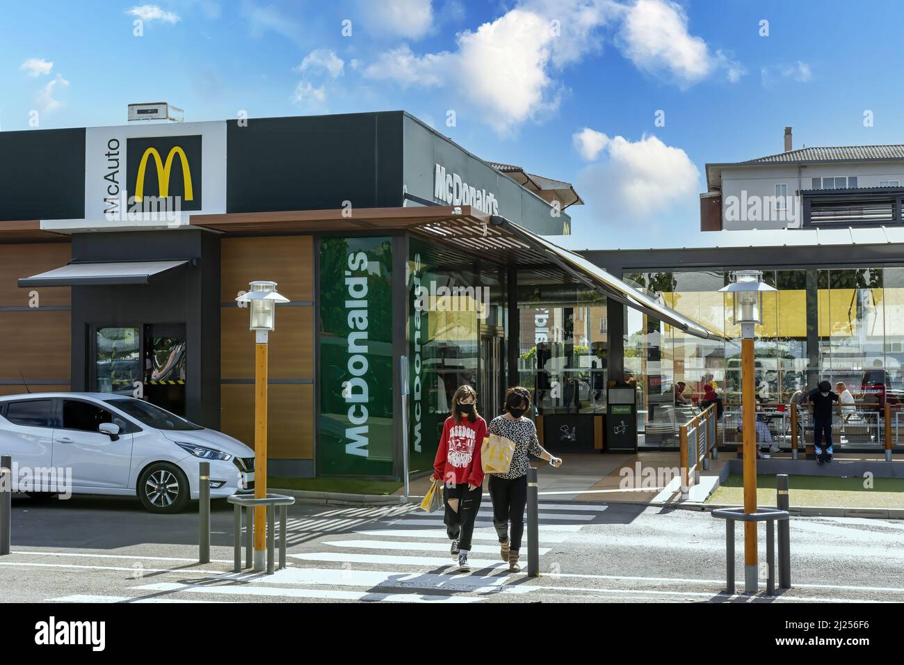 Teruel, Spagna, 12-10-2021, diverse persone soddisfatte lasciano un ristorante fast food dopo aver messo il loro ordine, cielo blu, fast food concetto Foto Stock