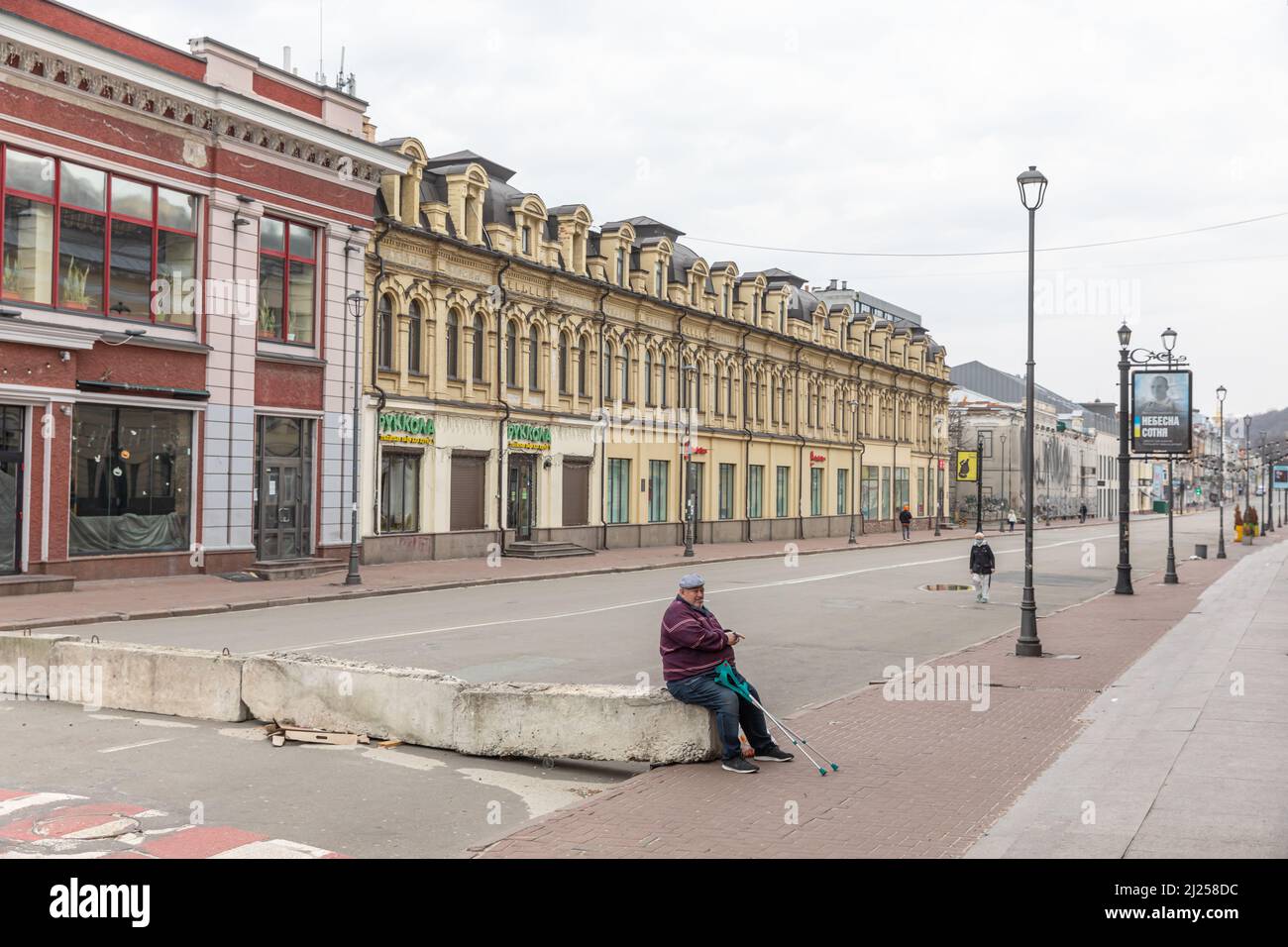 Kiev, Ucraina. 26th Mar 2022. Un uomo si siede sul marciapiede lungo la strada vuota di Kyiv. La Russia ha invaso l'Ucraina il 24 febbraio 2022, scatenando il più grande attacco militare in Europa dalla seconda guerra mondiale Oltre 3 milioni di ucraini hanno già lasciato il paese e la storica città portuale di Odessa è sotto la minaccia di bombardamenti da parte delle forze russe. (Credit Image: © Mykhaylo Palinchak/SOPA Images via ZUMA Press Wire) Foto Stock