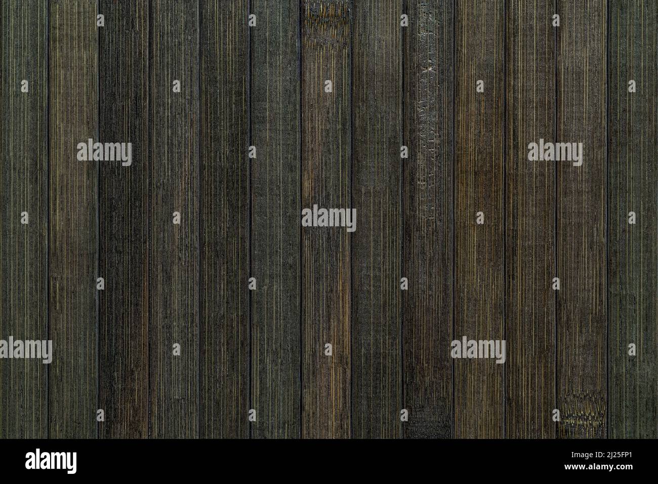 Macro texture di assi verticali di bambù laccato con disegno a strisce. Sfondo di tavole di bambù nero verdastro. Interni di design elemen. Foto Stock