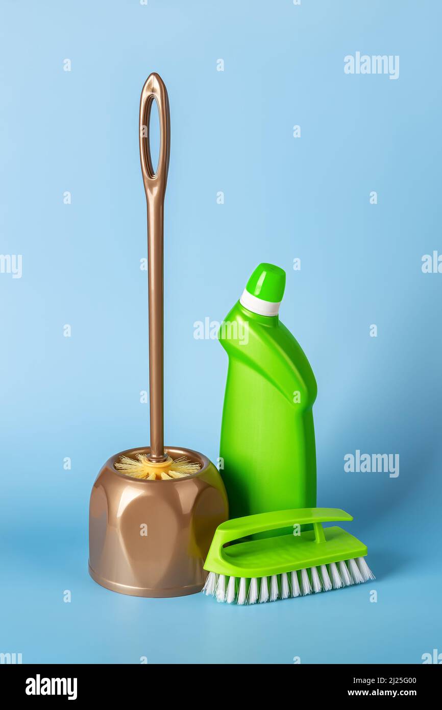 Spazzola per WC con supporto, spazzola per la pulizia e detergente per wc su sfondo blu. Set di attrezzature per utensili per lavori domestici di routine. Foto Stock