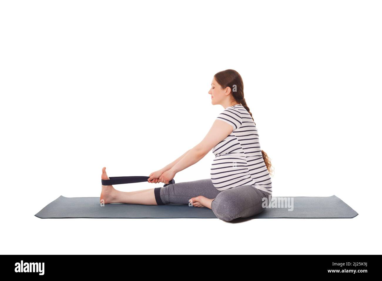 Donna incinta che fa yoga asana Janu Sirsasana A. Foto Stock