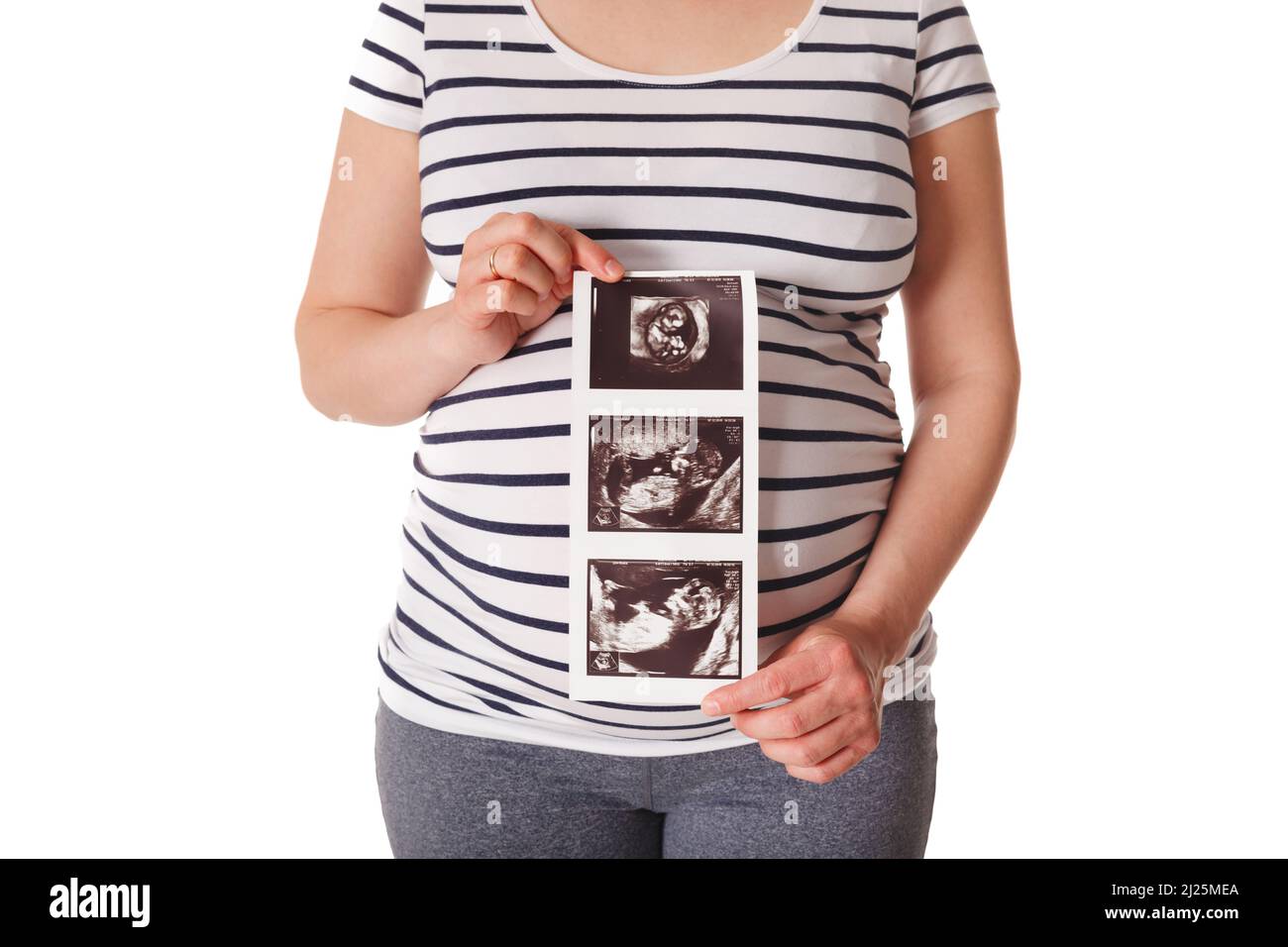 Donna incinta in piedi e tenendo la sua scansione del bambino a ultrasuoni Foto Stock