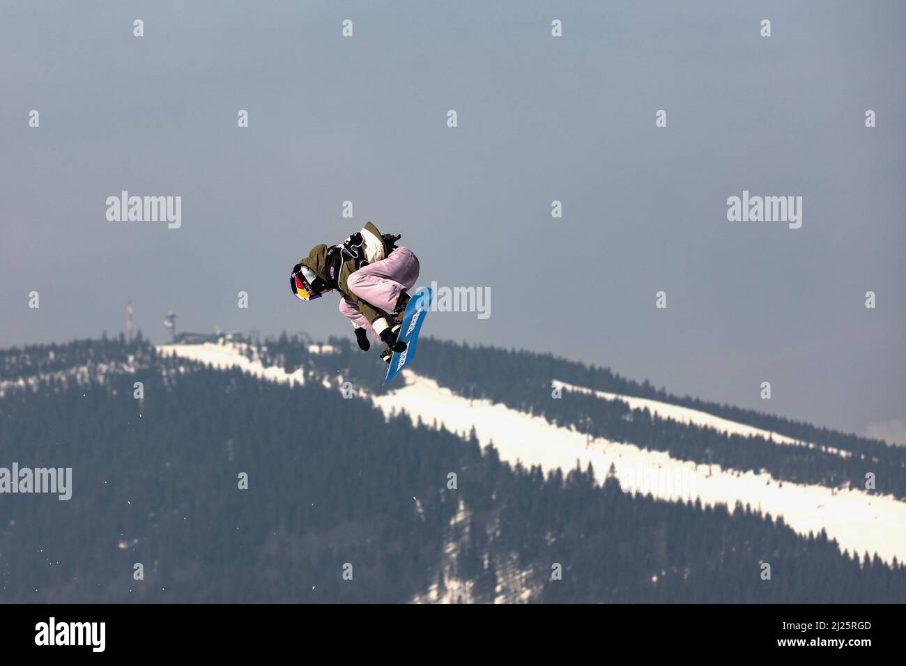 SPINDLERUV MLYN, REPUBBLICA CECA - 18th marzo. 2022: Snowboarder che salta contro il cielo blu. Snowboard. Un giovane snowboarder salta nello Spindleruv ml Foto Stock