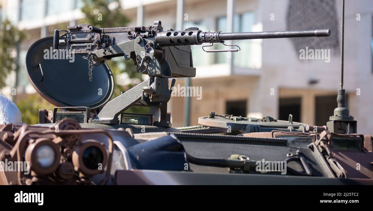 m2 machinegun Browning su un veicolo di trasporto del personale Armored, parata militare. Armi pesanti di guerra, edifici della città sfondo. Attrezzatura militare per la lotta Foto Stock