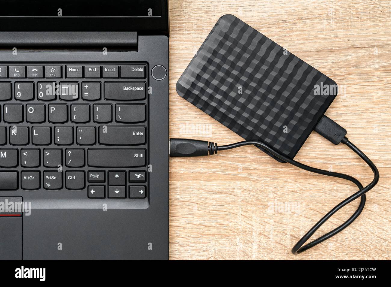 hdd portatile collegato a un computer portatile su sfondo di legno, vista dall'alto. Il concetto di memorizzazione dei dati Foto Stock