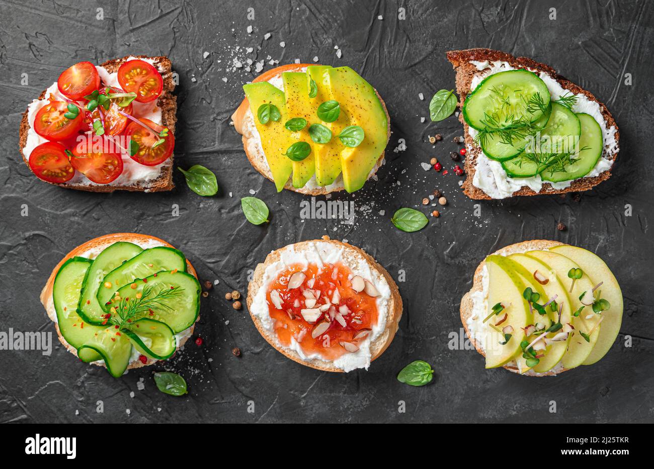 Panini assortiti con verdure e frutta su formaggio cremoso. Foto Stock