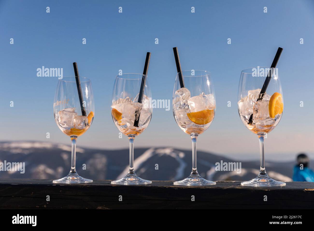 Medvedin, lettere in legno in cima alla stazione sciistica. Vetro su Aperol Spritz in primo piano dell'iscrizione Medvedi. Adatto per pubblicità w Foto Stock