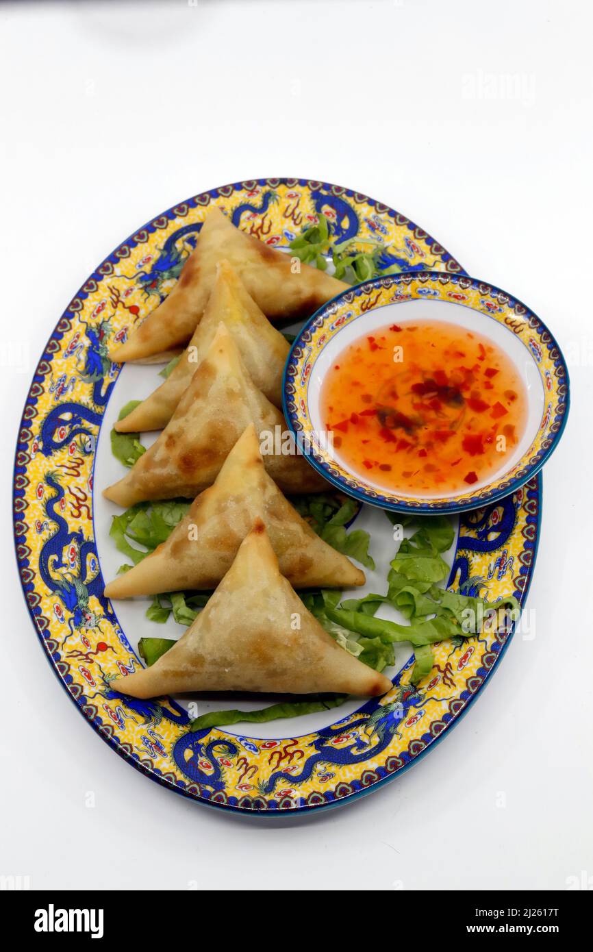 Cucina asiatica. La samosa è una pasta che solitamente viene riempita con una saporita combinazione di verdure o di carne o pesce sminuzzati stagionati. Foto Stock