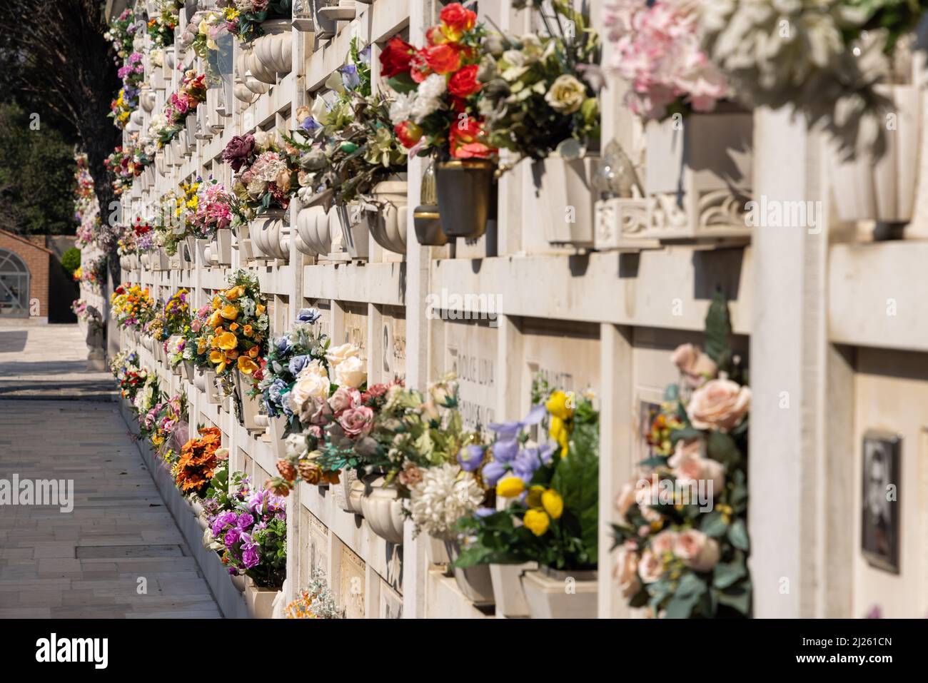 Cimitero murale italiano con lapidi e fiori artificiali in una soleggiata  giornata estiva a Venezia, Isola di San Michele. Commemorazione dei morti  Foto stock - Alamy