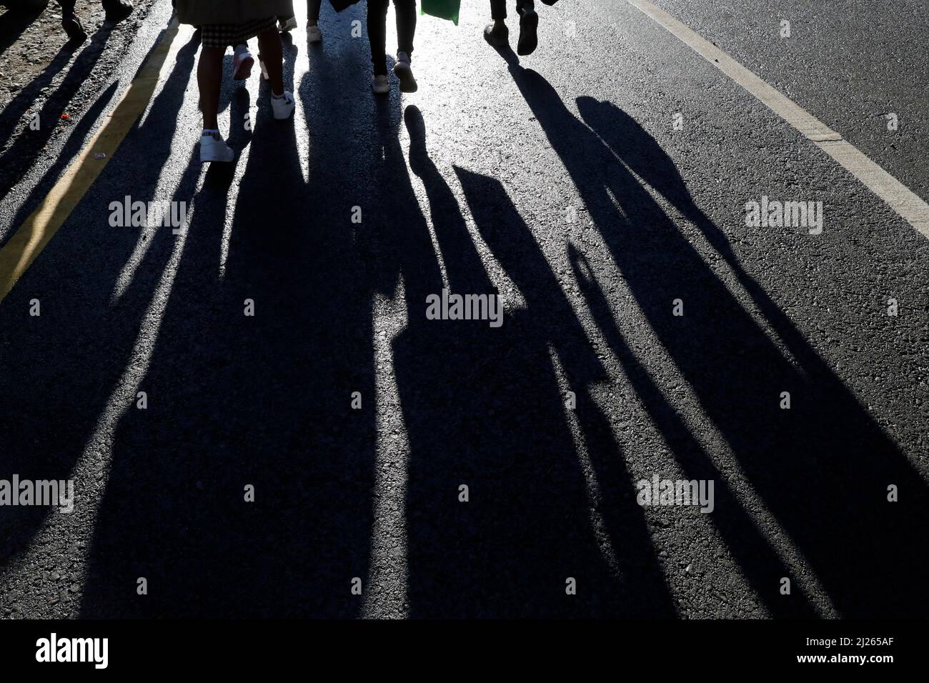 Sagome nere e ombre delle persone per strada. Folla che cammina sul marciapiede, concetto di pedoni, crimine, società, vita cittadina. Foto Stock
