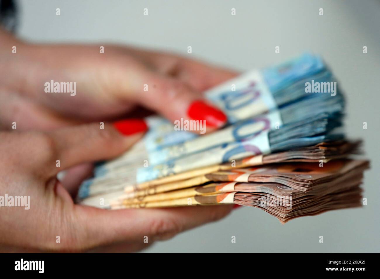 Donna in possesso di banconote e banconote in euro. Concetto di rubare denaro, persone ricche, risparmi o spendere denaro. Pagamento in conto. Foto Stock