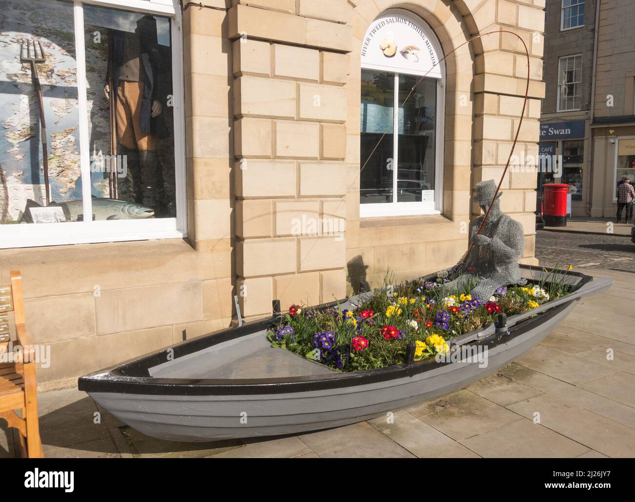 Una scultura di una persona che pesca all'interno di una barca a remi all'esterno del River Tweed Museum of Salmon Fishing nel municipio di Kelso, Scottish Borders, Scozia. Foto Stock