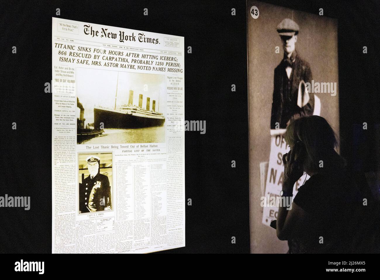 La mostra Titanic; un visitatore che guarda i titoli dei giornali del tempo dopo l'affondamento RMS Titanic nel 1912; Londra UK Foto Stock