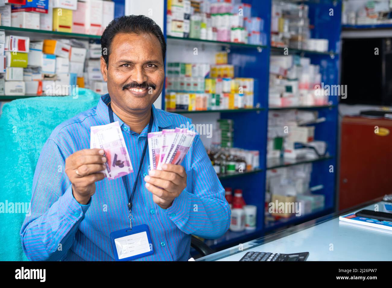 Buon farmacista couting denaro al banco - concetto di business di successo, guadagni o profitto e negozio di medicina al dettaglio. Foto Stock