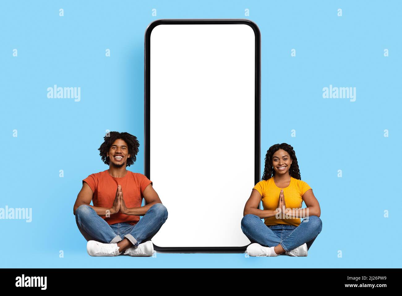 Coppia nera rilassata seduta da smartphone enorme con schermo vuoto Foto Stock