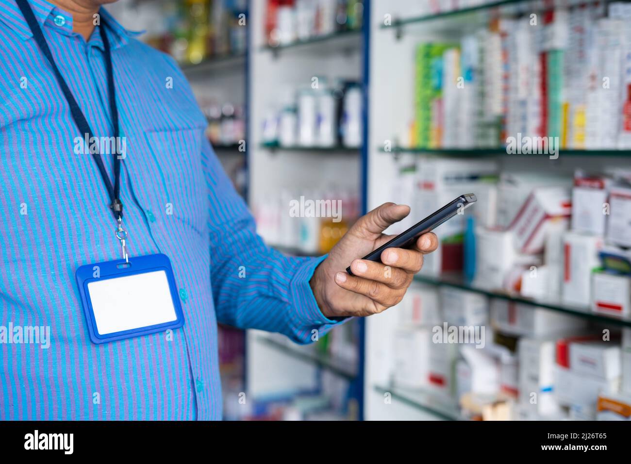 Primo piano di farmacista occupato utilizzando il telefono cellulare al negozio di farmacia medico con spazio copia - concetto di prendere pausa, controllare le scorte o. Foto Stock