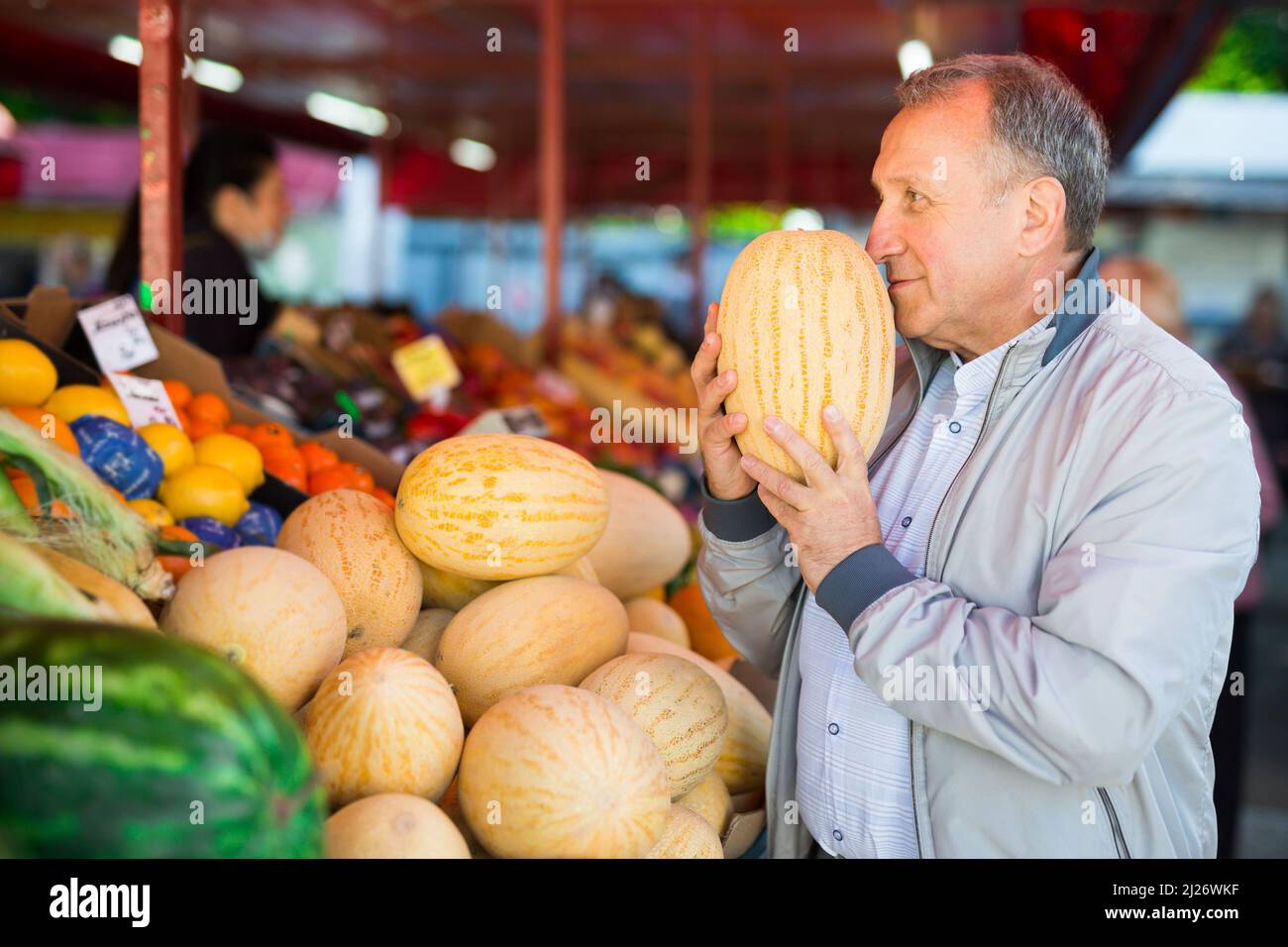 Uomo di mezza età che acquista melone Foto Stock