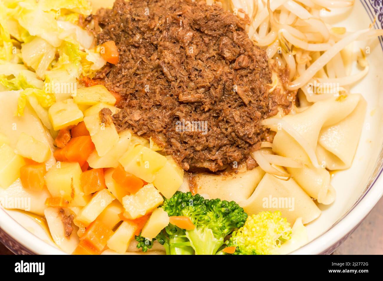 Tradizionale carne di maiale cinese cotta in salsa salata e fragrante, poi servita con spaghetti e verdure varie (Zha Jiang Mian) Foto Stock