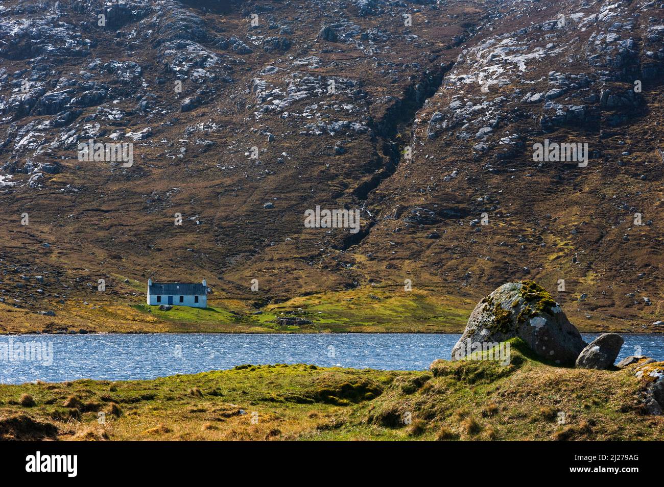 Cravadale Lodge visto attraverso Loch na Cleabhaig vicino Huishinish su Harris nelle Ebridi esterne Foto Stock