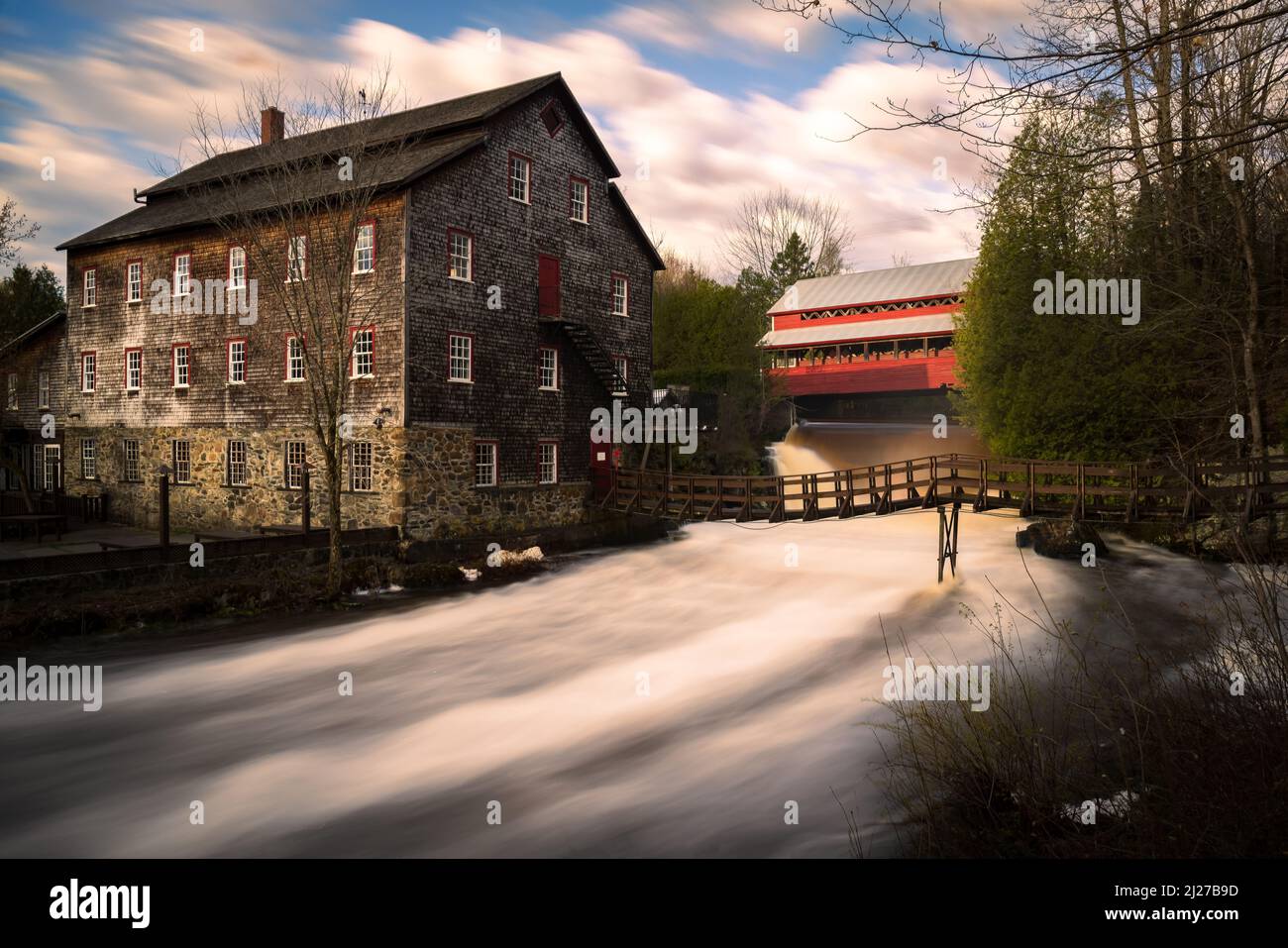 ulverton mulino di lana comunale, con il suo ponte coperto di legno rosso. Foto Stock