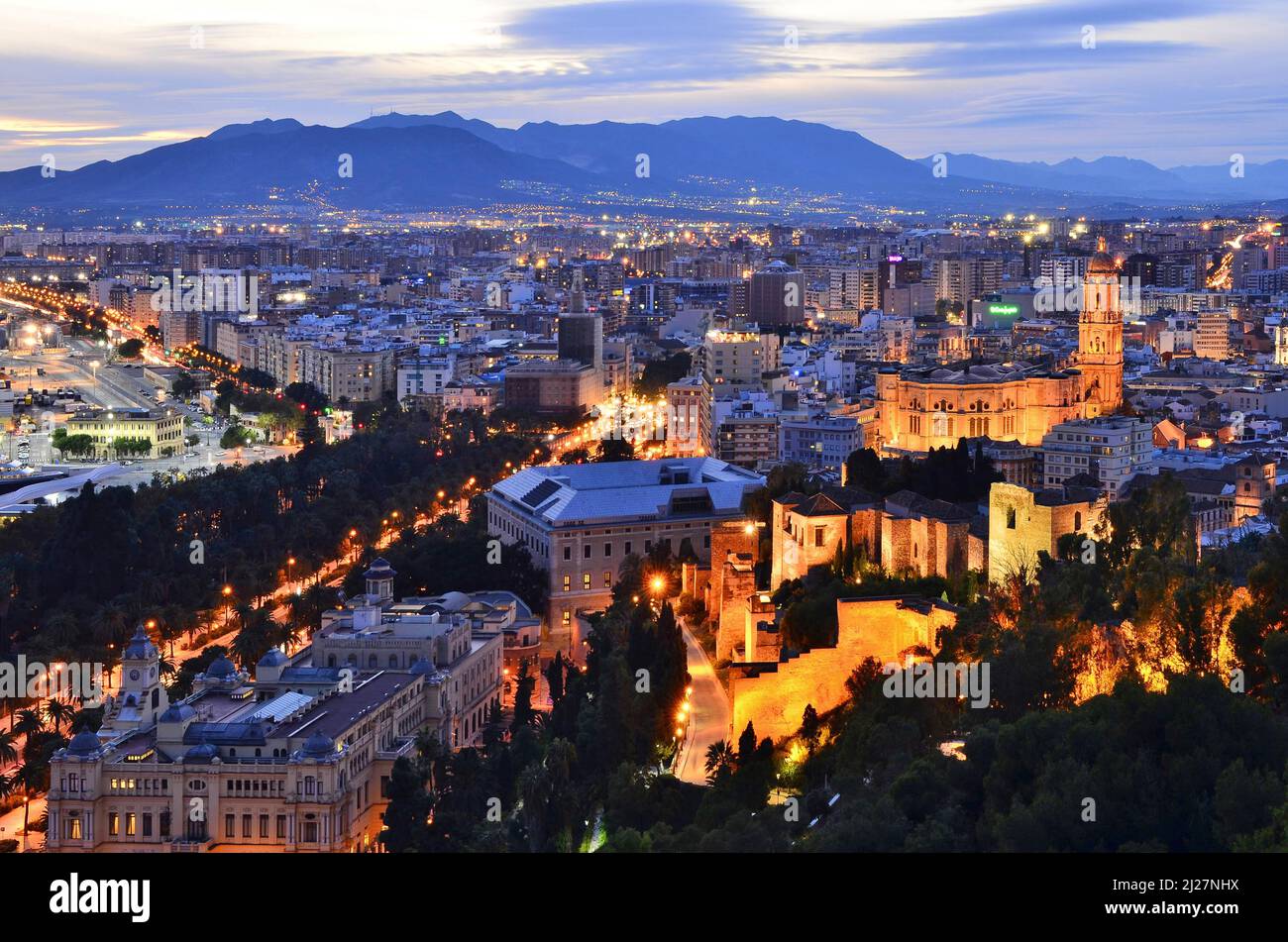 Città di Malaga con la fortezza medievale di Alcazaba e la cattedrale illuminata al crepuscolo, vista elevata dalla collina di Gibralfaro, Andalusia Spagna. Foto Stock