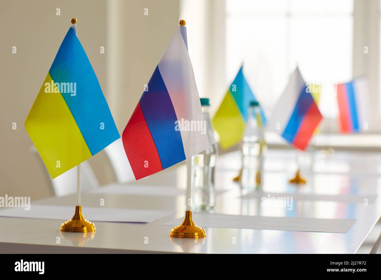 Tavolo con bandiere di Russia e Ucraina nella sala conferenze dopo la riunione di negoziazione Foto Stock