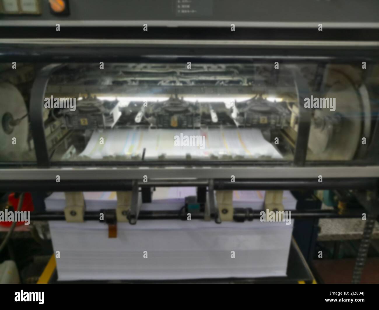 Immagine sfocata di una moderna macchina da stampa a quattro colori funzionante ad alta velocità. Girato a Kolkata, Bengala Occidentale, India. Foto Stock