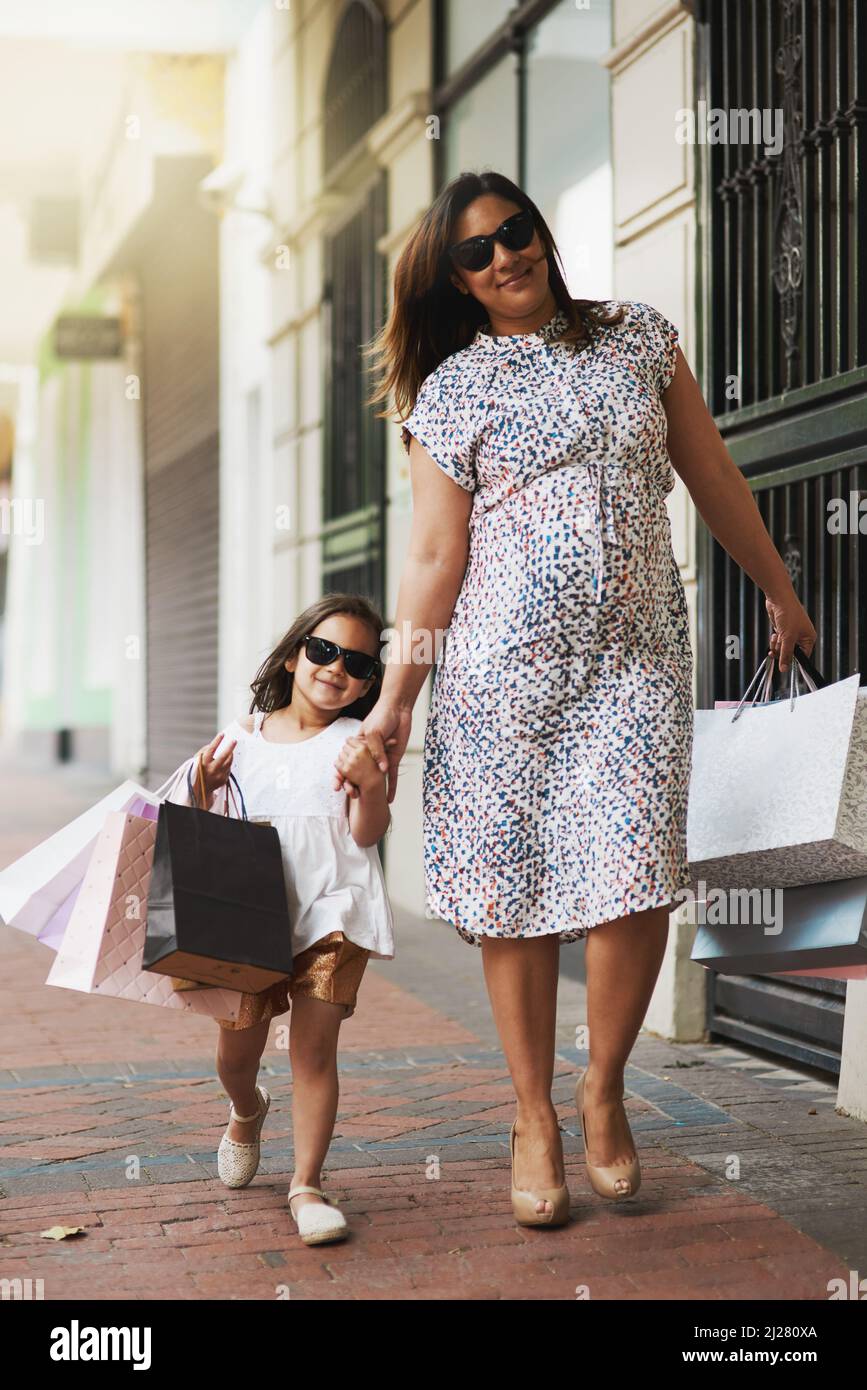 Le ragazze saranno ragazze. Ritratto di una madre e sua figlia piccola fuori per uno shopping spree in città. Foto Stock