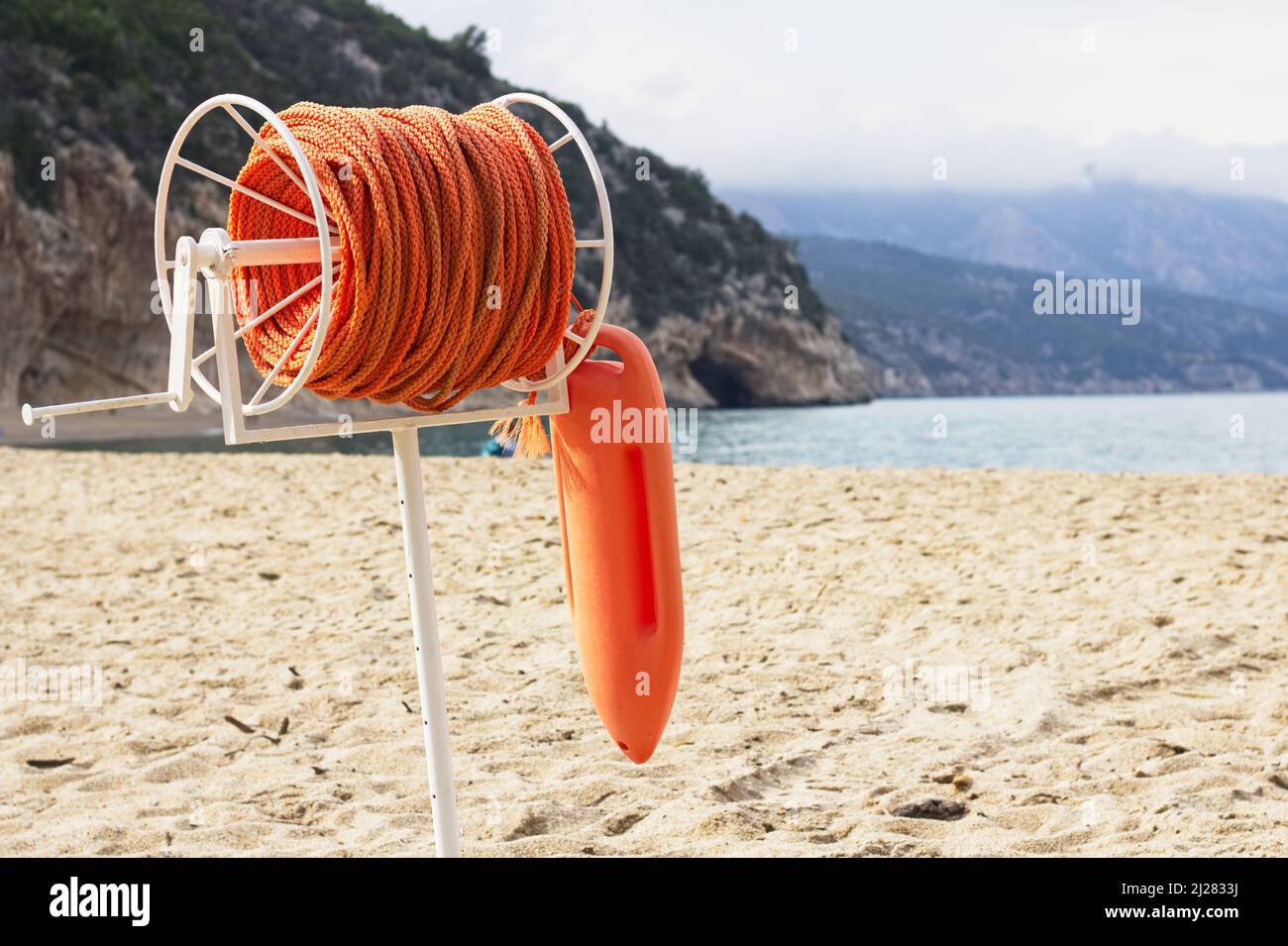 Boa e corda di salvataggio marina sulla spiaggia di Cala Luna, Sardegna. Salvavvita sulla costa Foto Stock