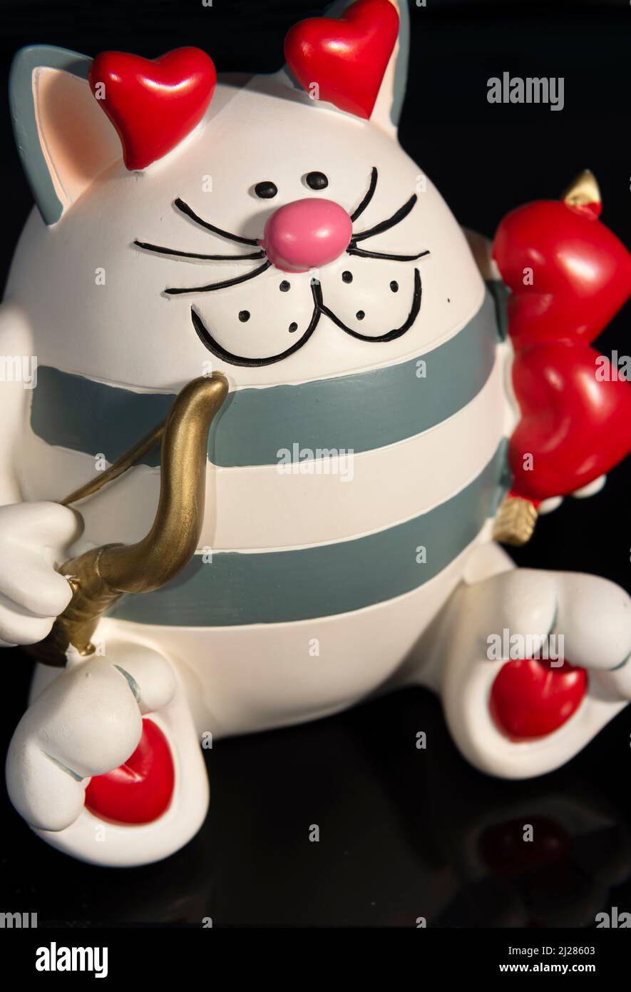Una cassa di denaro di novità sotto forma di un gatto di cupide di caricatura. Foto Stock