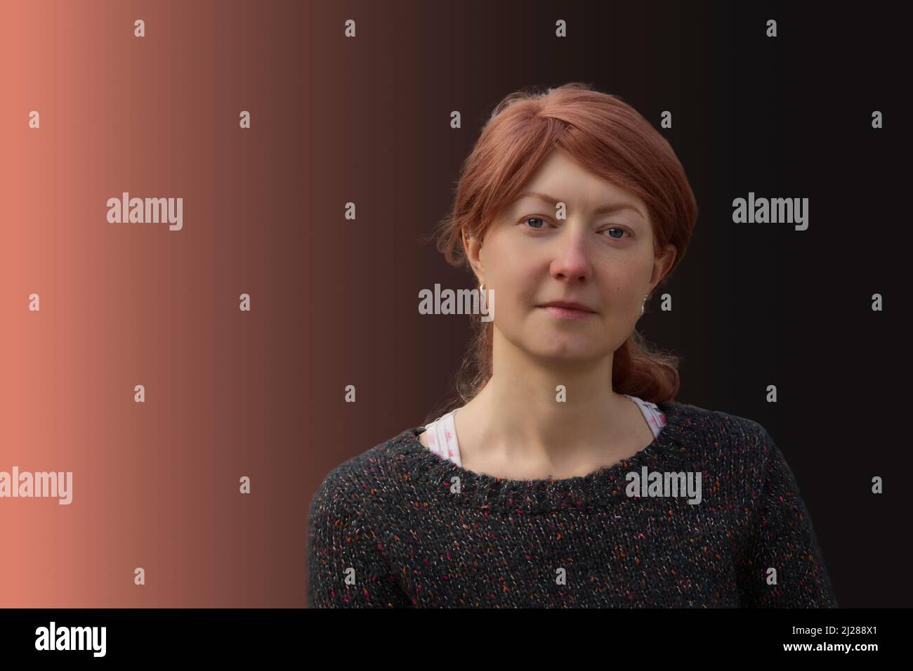Ritratto di una donna dai capelli rossi su sfondo rosso-nero Foto Stock