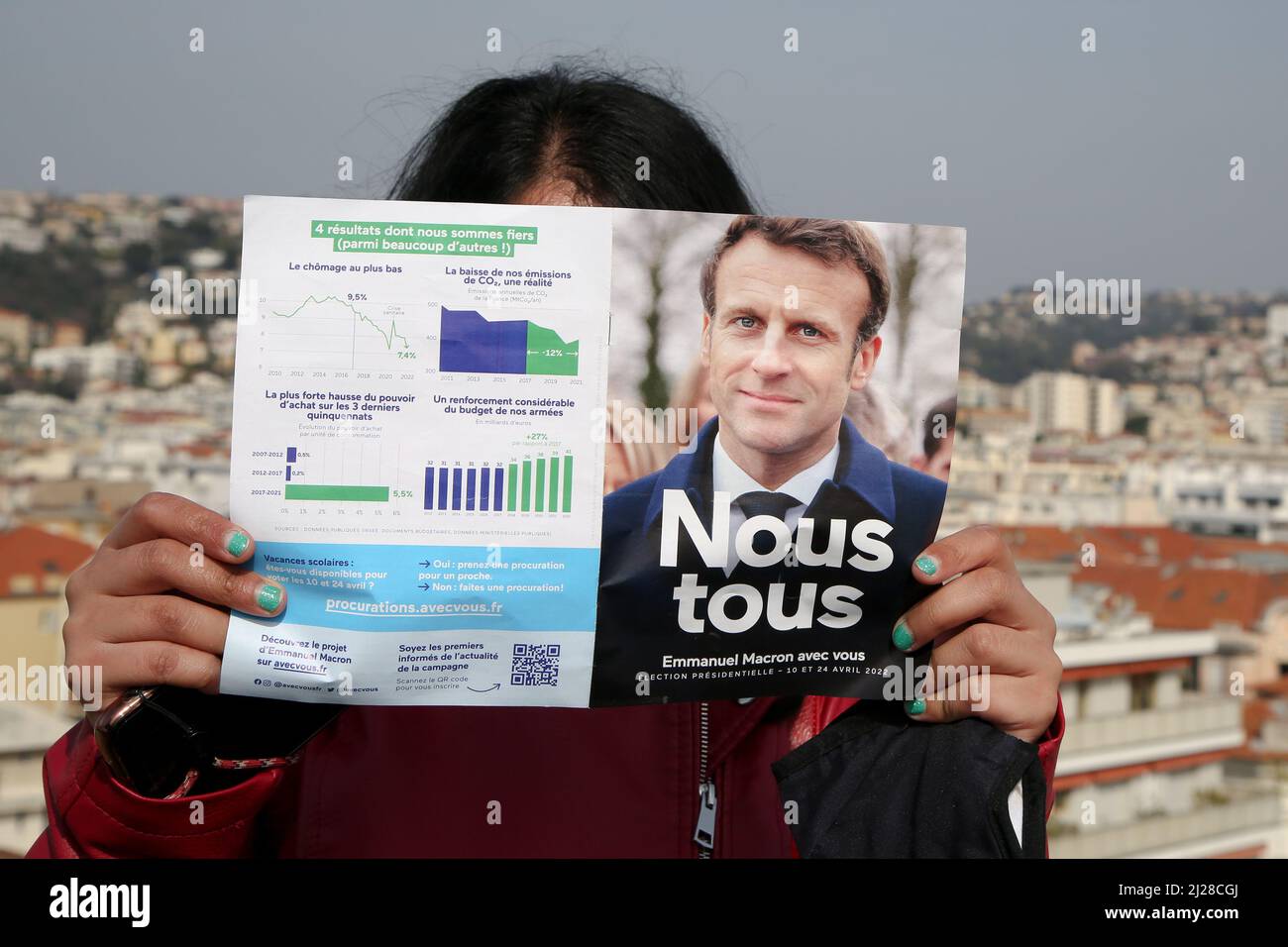 Nizza, Francia. 29th Mar 2022. Una donna legge il volantino delle elezioni presidenziali del 2022 di Emmanuel Macron con una visione delle proprietà a Nizza. Il primo turno delle elezioni presidenziali francesi del 2022 si svolgerà domenica 10th aprile 2022. Credit: SOPA Images Limited/Alamy Live News Foto Stock