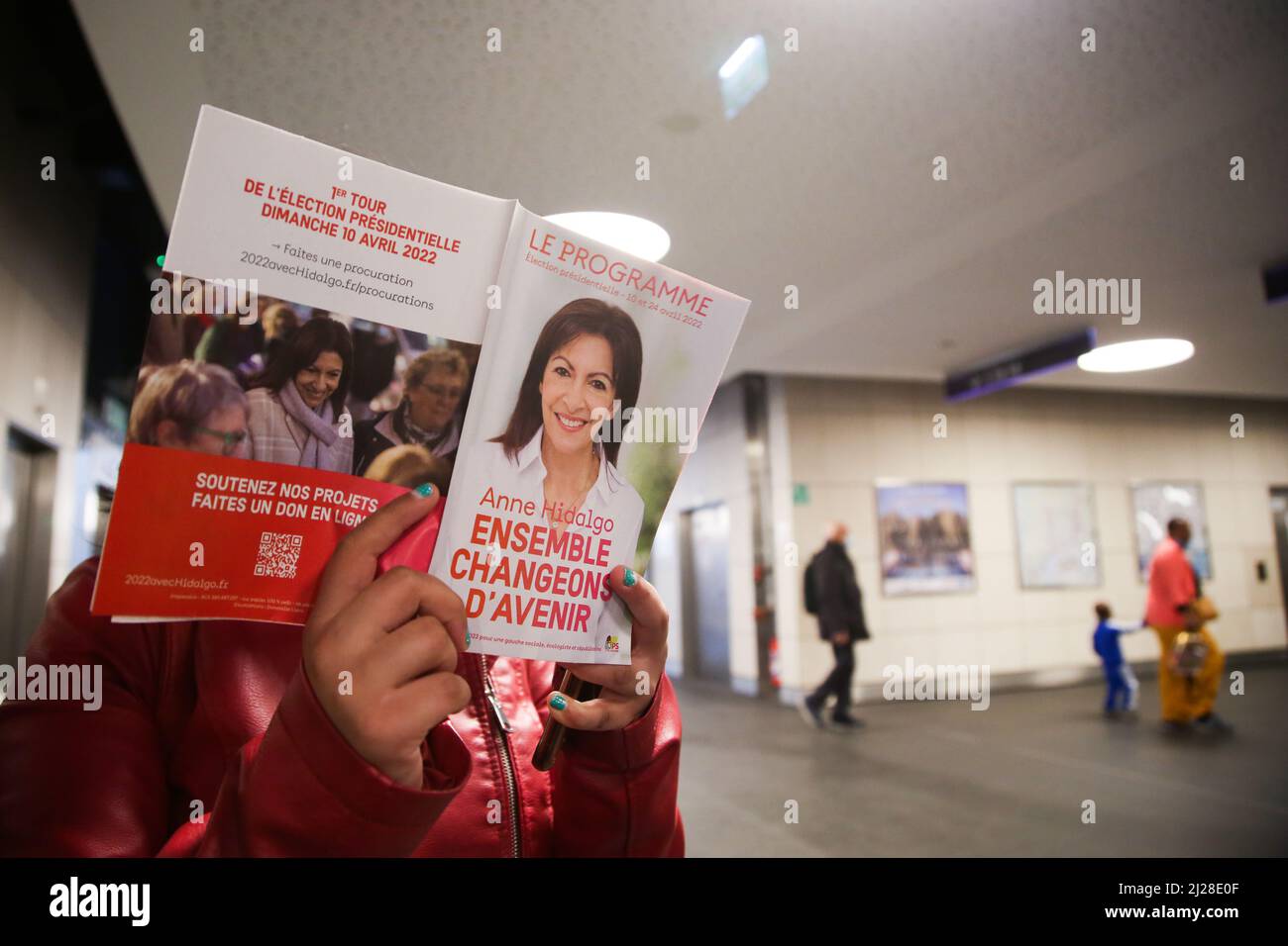 Nizza, Francia. 29th Mar 2022. Una donna legge il sindaco di Parigi e il partito socialista candidato per l'elezione presidenziale francese del 2022 Anne Hidalgo, volantino di una stazione ferroviaria. Il primo turno delle elezioni presidenziali francesi del 2022 si svolgerà domenica 10th aprile 2022. (Foto di Dinendra Haria/SOPA Images/Sipa USA) Credit: Sipa USA/Alamy Live News Foto Stock