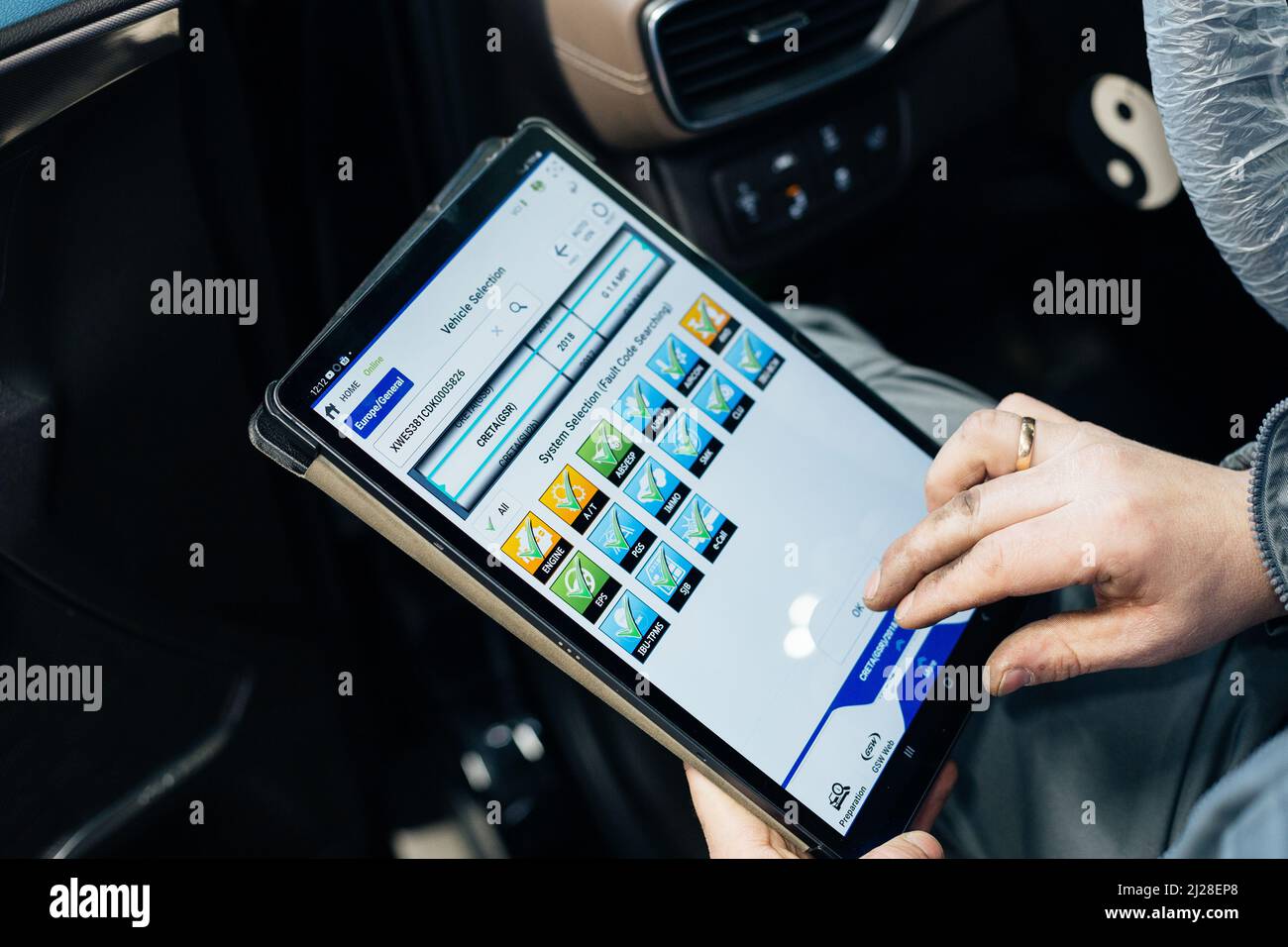 L'ingegnere maschio fa la diagnostica del calcolatore della vettura in servizio auto. Foto Stock