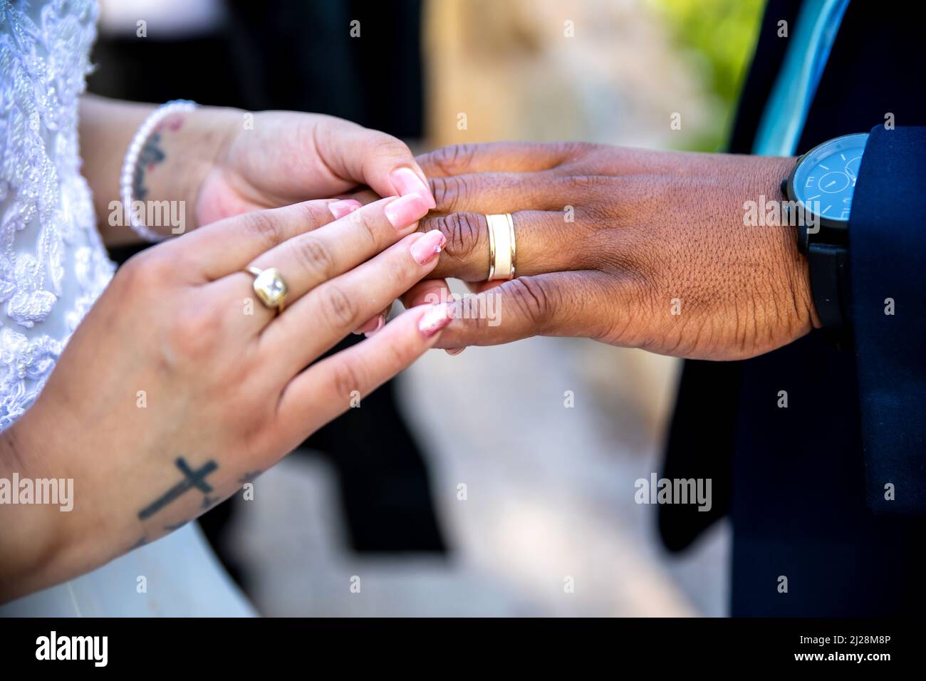 Bride mettendo anello sul dito dello sposo Foto Stock