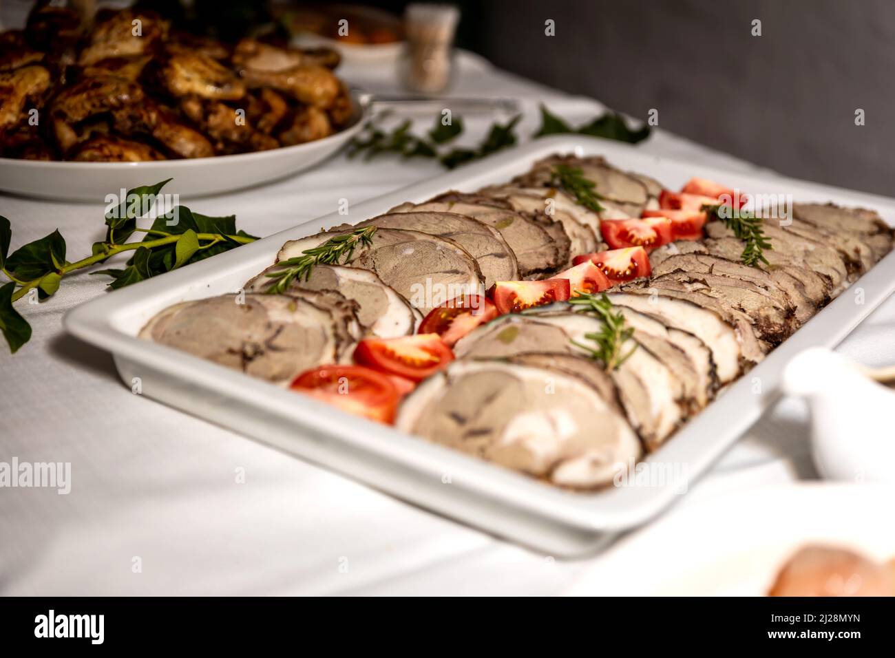 Fette di carne arrosto tagliate a freddo su un piatto bianco Foto Stock