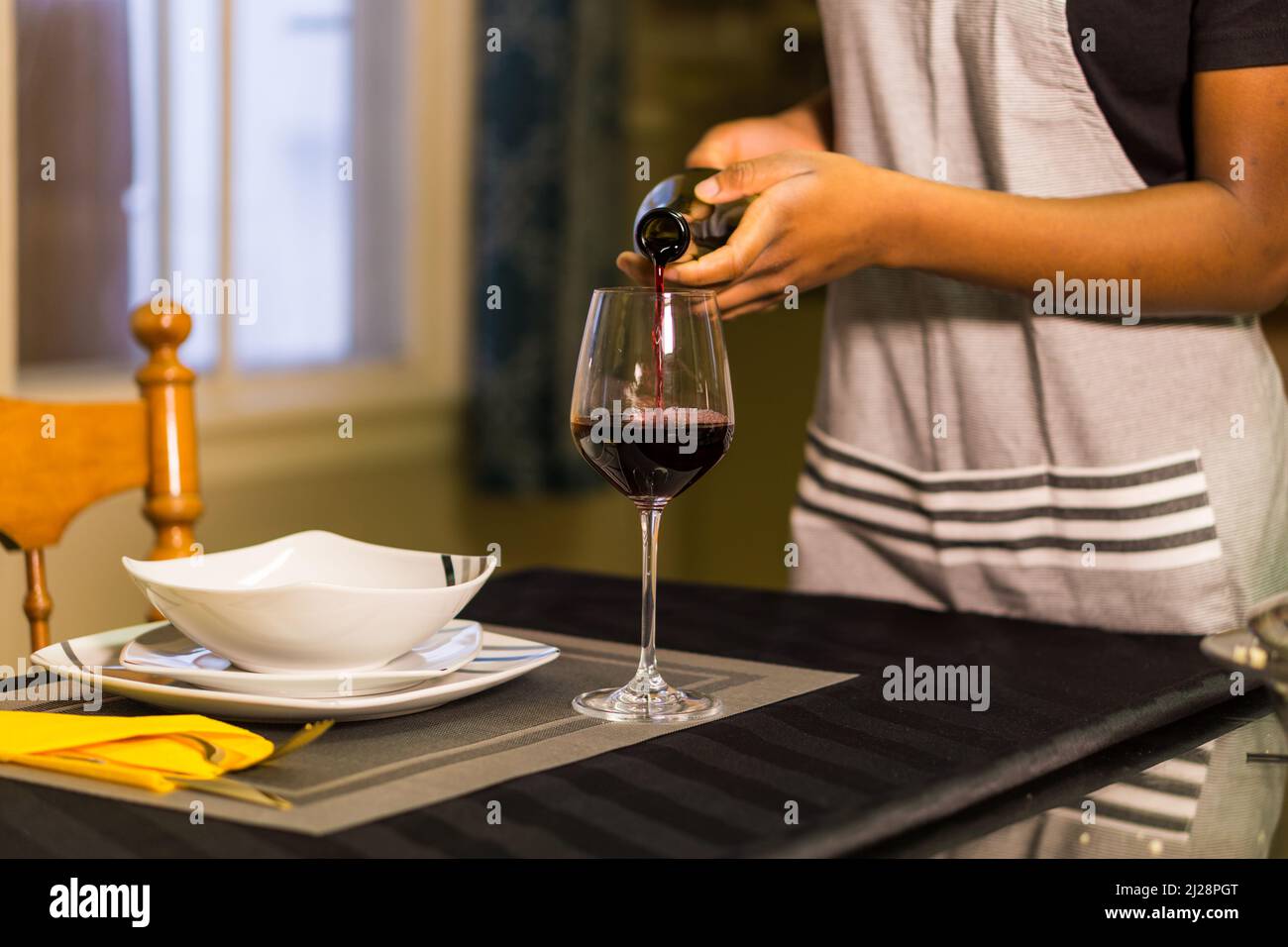 cena con un bicchiere di vino rosso e una bottiglia in una giornata di sole Foto Stock